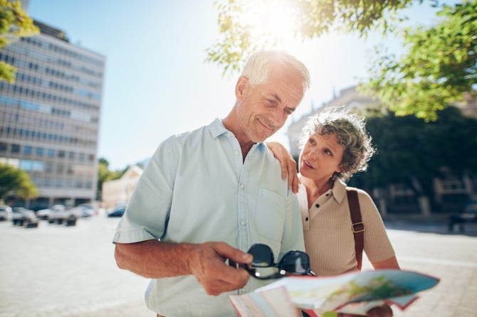 Senior couple in a foreign city using a road map. Mature couple on a vacation using map for directions.