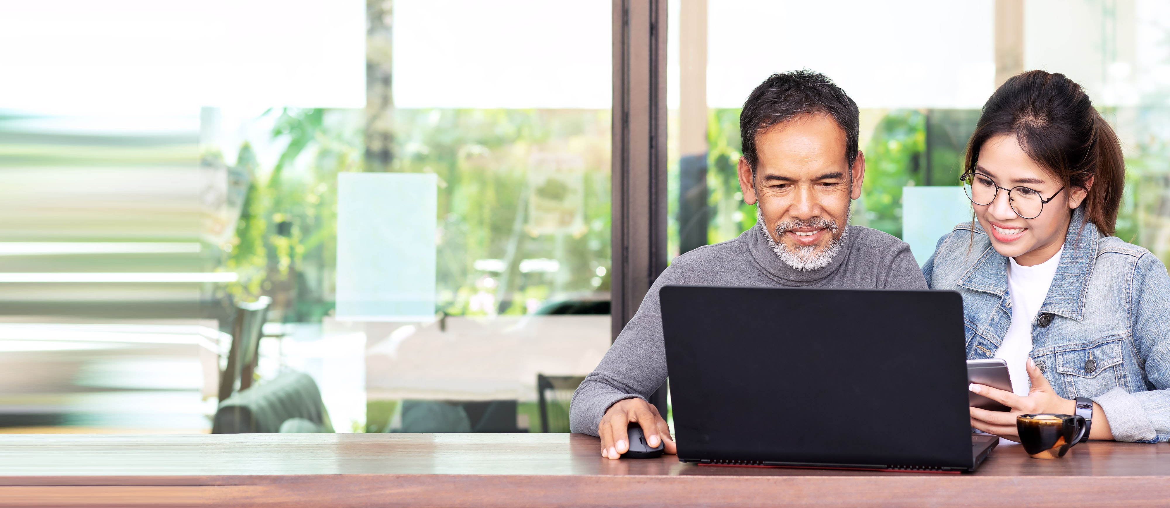 man and woman sit in front of computer